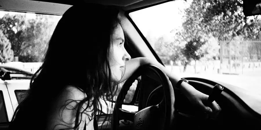 Amy Anders - woman with long dark hair in the driver's seat of a car
