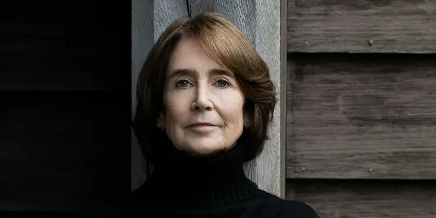 Woman with brown hair wearing a black turtleneck by Beowulf Sheehan 