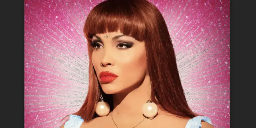 headshot of woman with red hair and bold makeup on a pink background