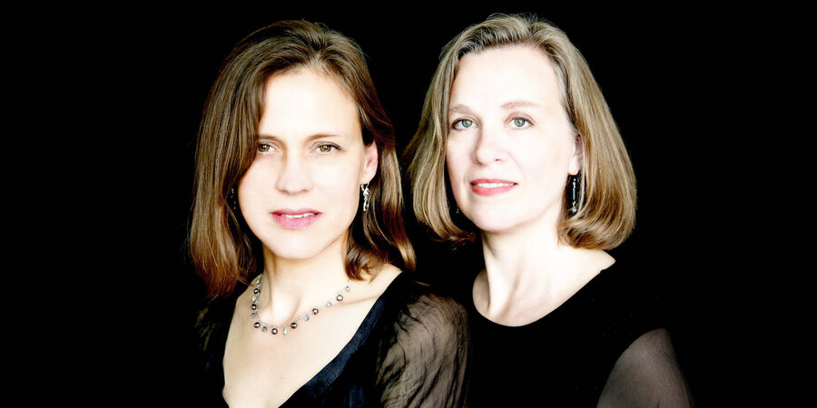 image of two female musicians in black against a black background