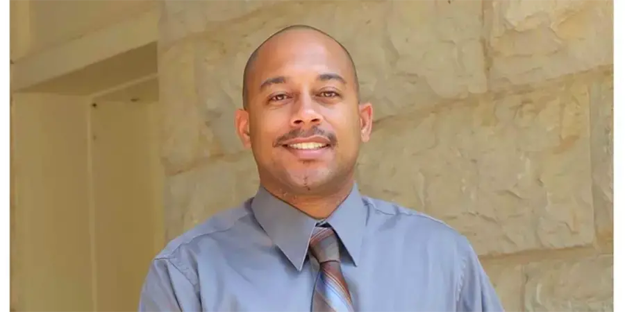 man wearing blue shirt smiles at camera