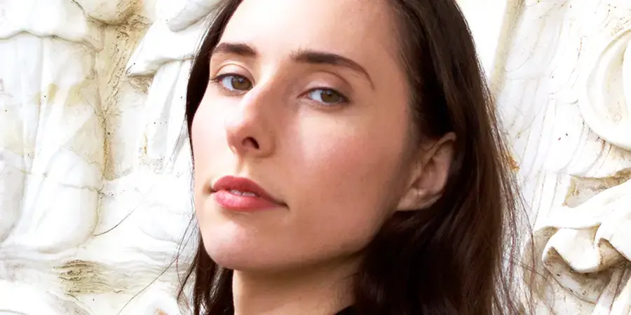 Nicolette Polek '15 woman with slim oval face and straight brown hair stares into camera