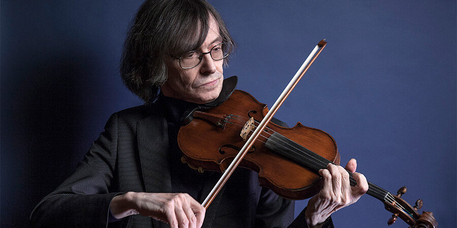 Rolf Schulte playing the violin against a blue background