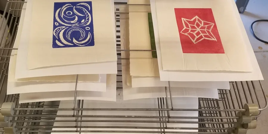 Image of snow farm linocut prints on rack