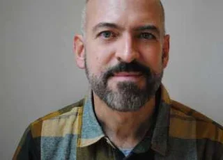 Photo of Paul Lisicky, bearded, starting at the camera