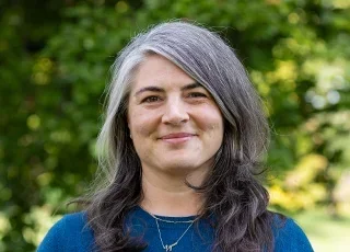 Lynne Valle headshot with tree in background