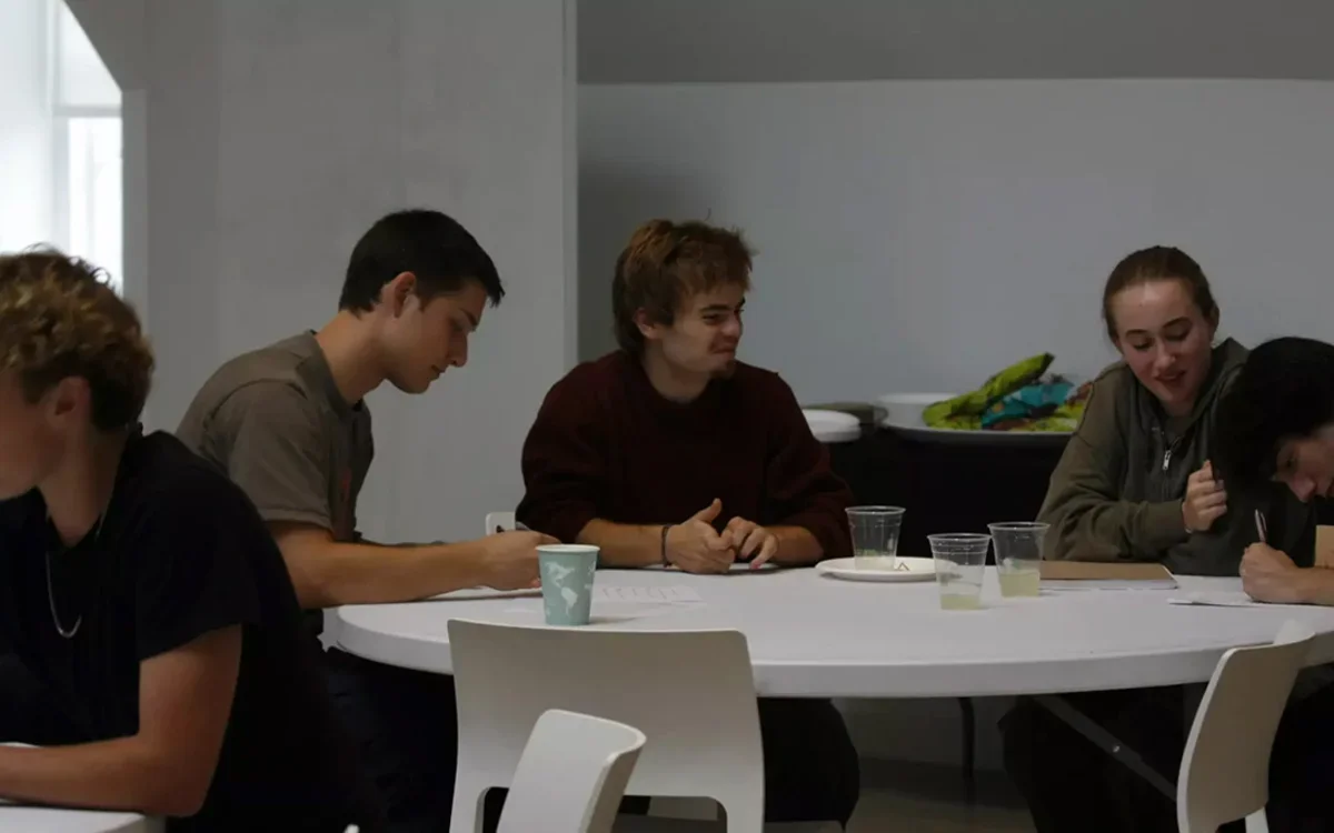 Three students discussing project around a table
