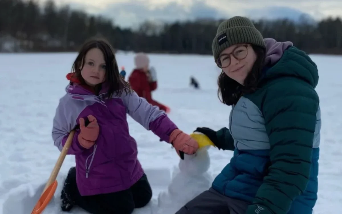 Image of Sofia Mirenda building snowman with student