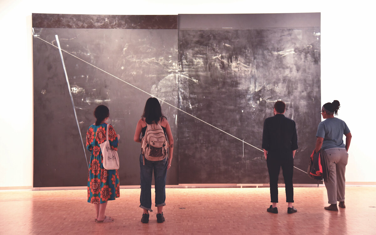 Museum goers observing a piece by Torkwase Dyson 