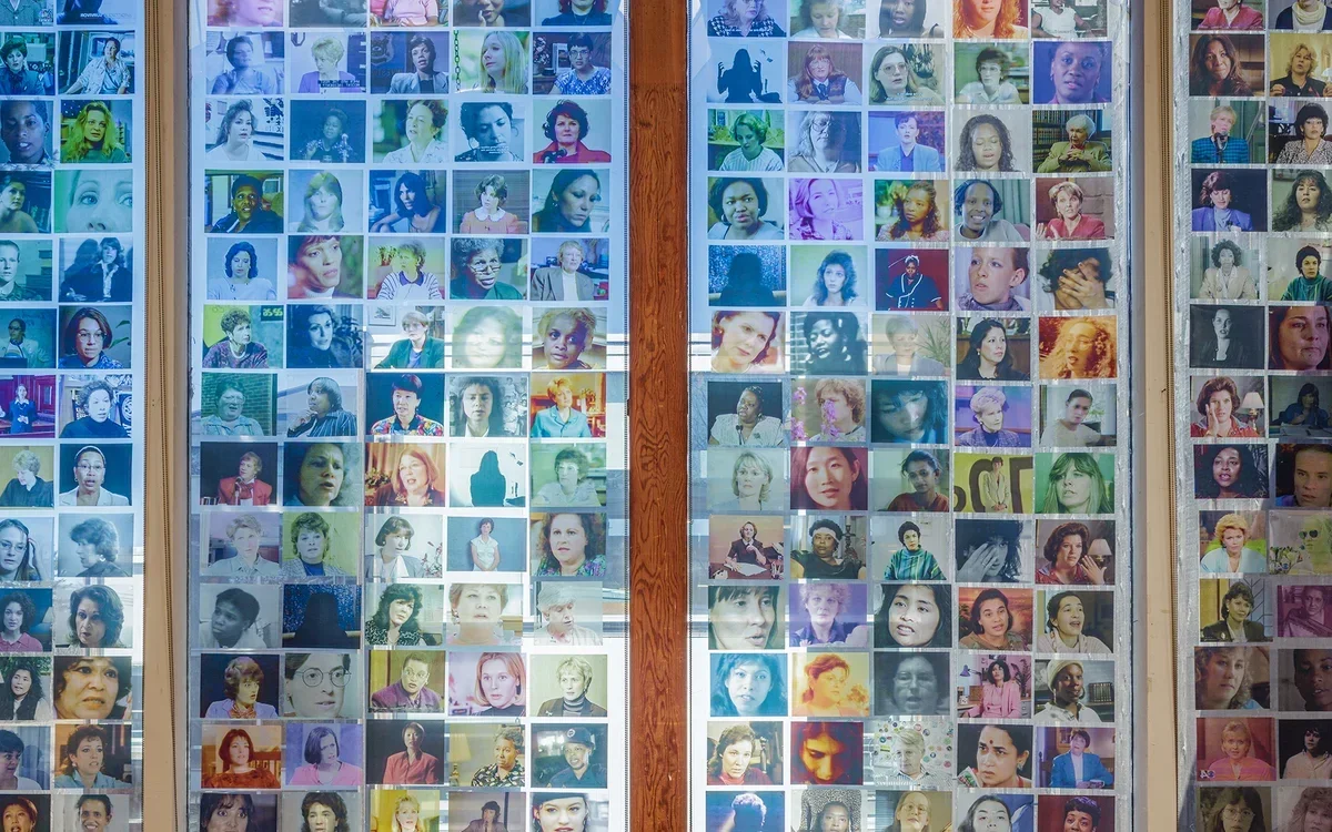 Image of women's photographs printed on transparency in a window from Double Jeopardy, an exhibition by  Carmen Winant at Usdan Gallery of Bennington College