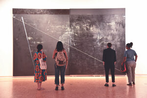 a group of students looking at a wall-sized work by dyson 