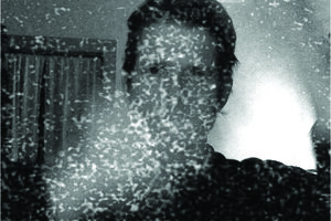 grey grainy photo of man with vapors obscuring face