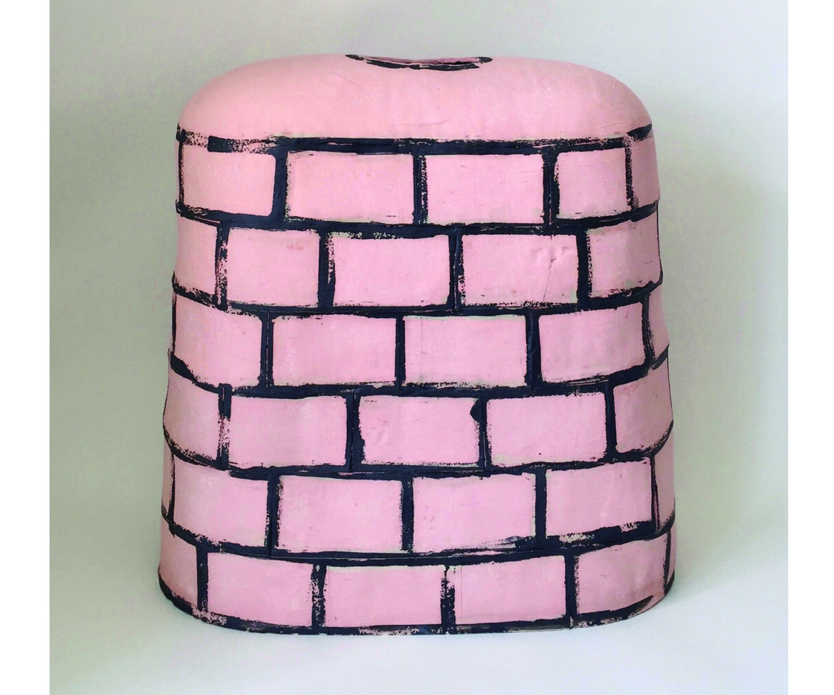 pink ceramics piece with black "brick" print over top