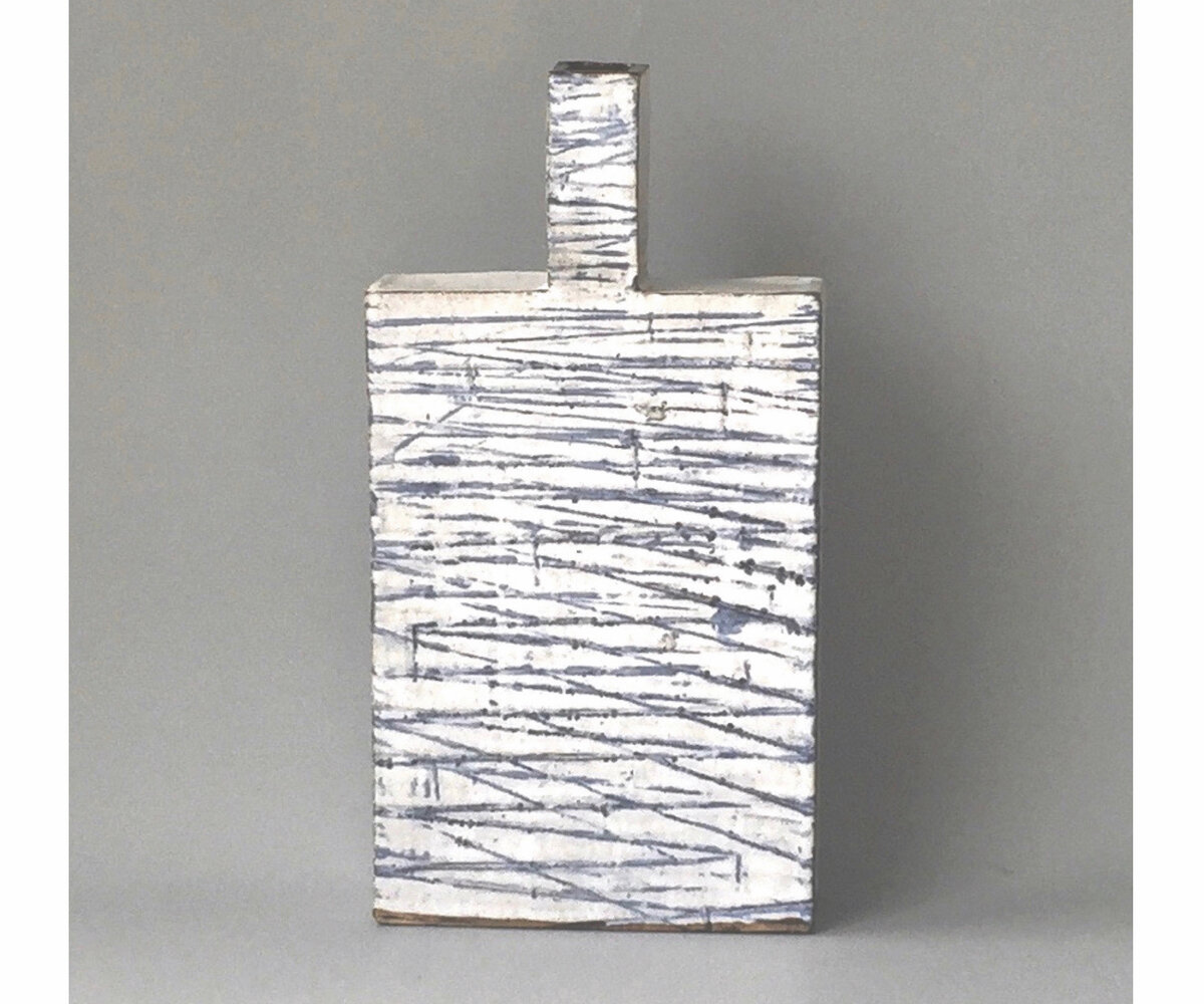 square white ceramics piece with with a blue overlay striped pattern and a small rectangular appendage at the top