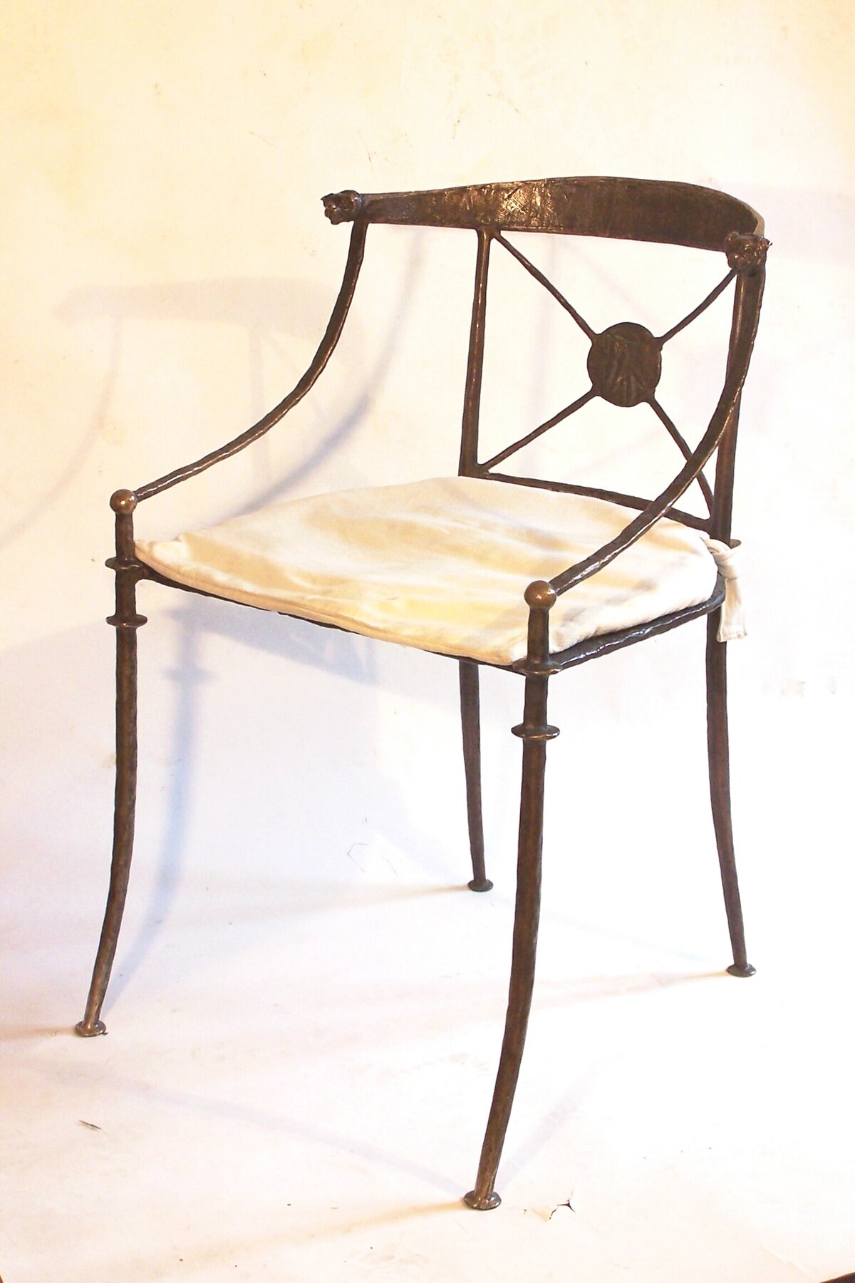bronze chair with thin legs and a white seat
