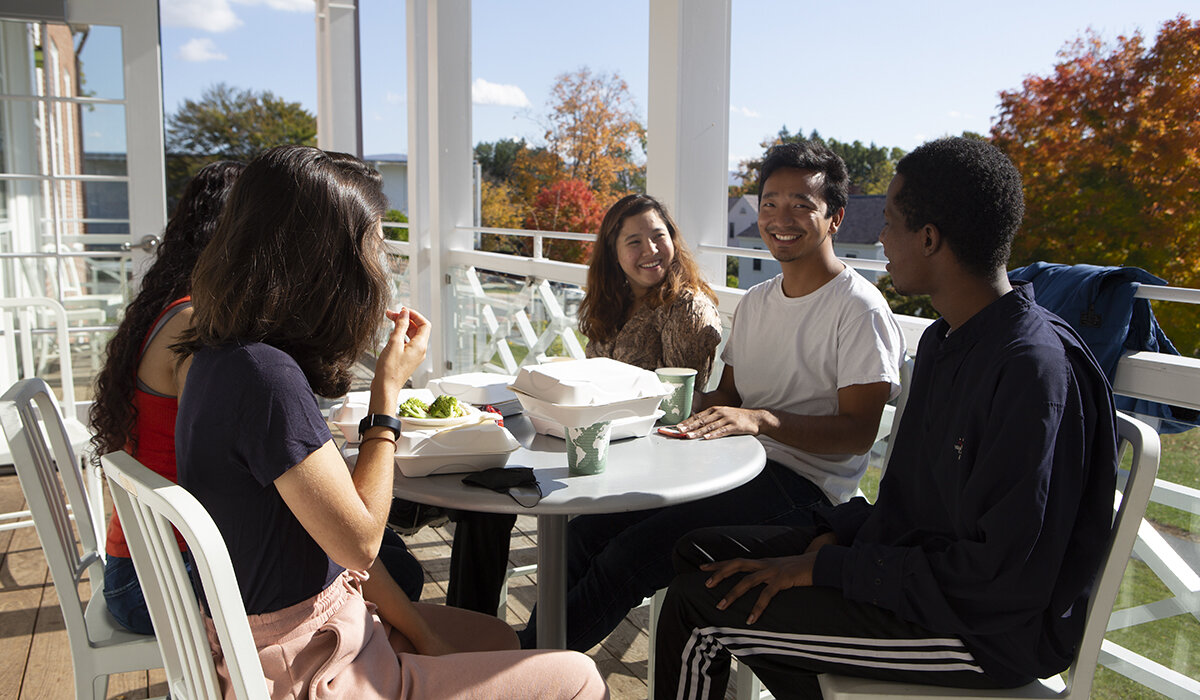 A group of students eating lunch on a porch
