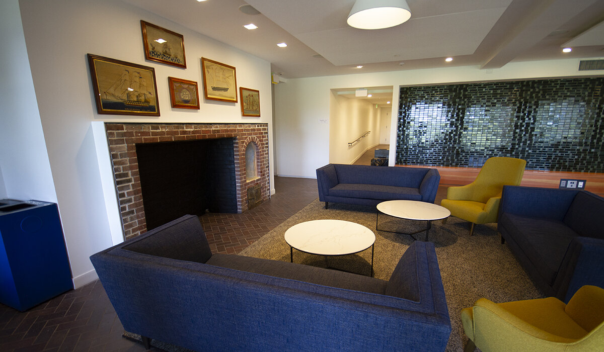commons lounge with chairs and couches and sailboat pictures on the wall