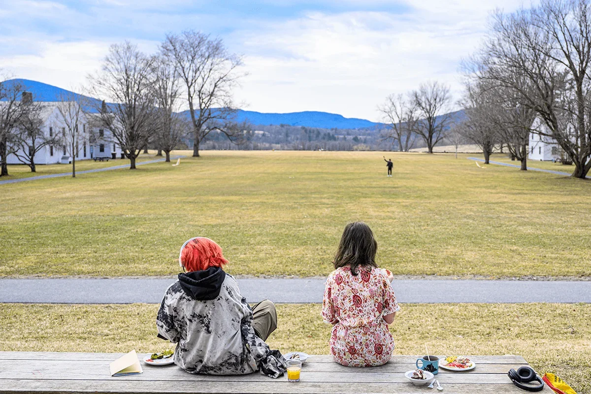 two students sit on a bench while looking towards the End of the World