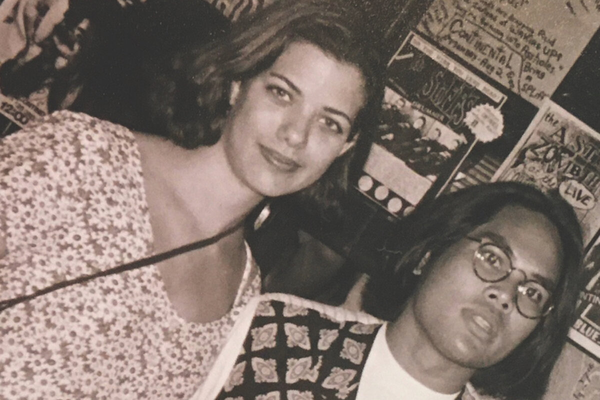 a man wearing glasses and a woman smile at the camera (sepia toned photo)