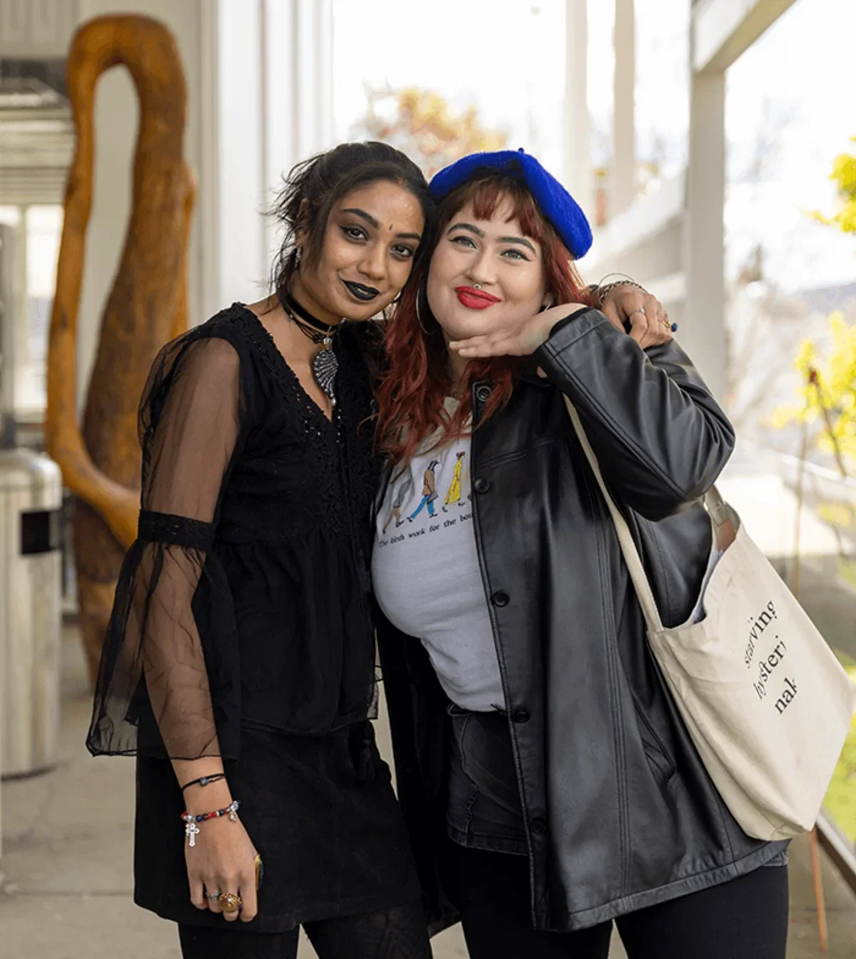 two stylish student pose for the camera smiling