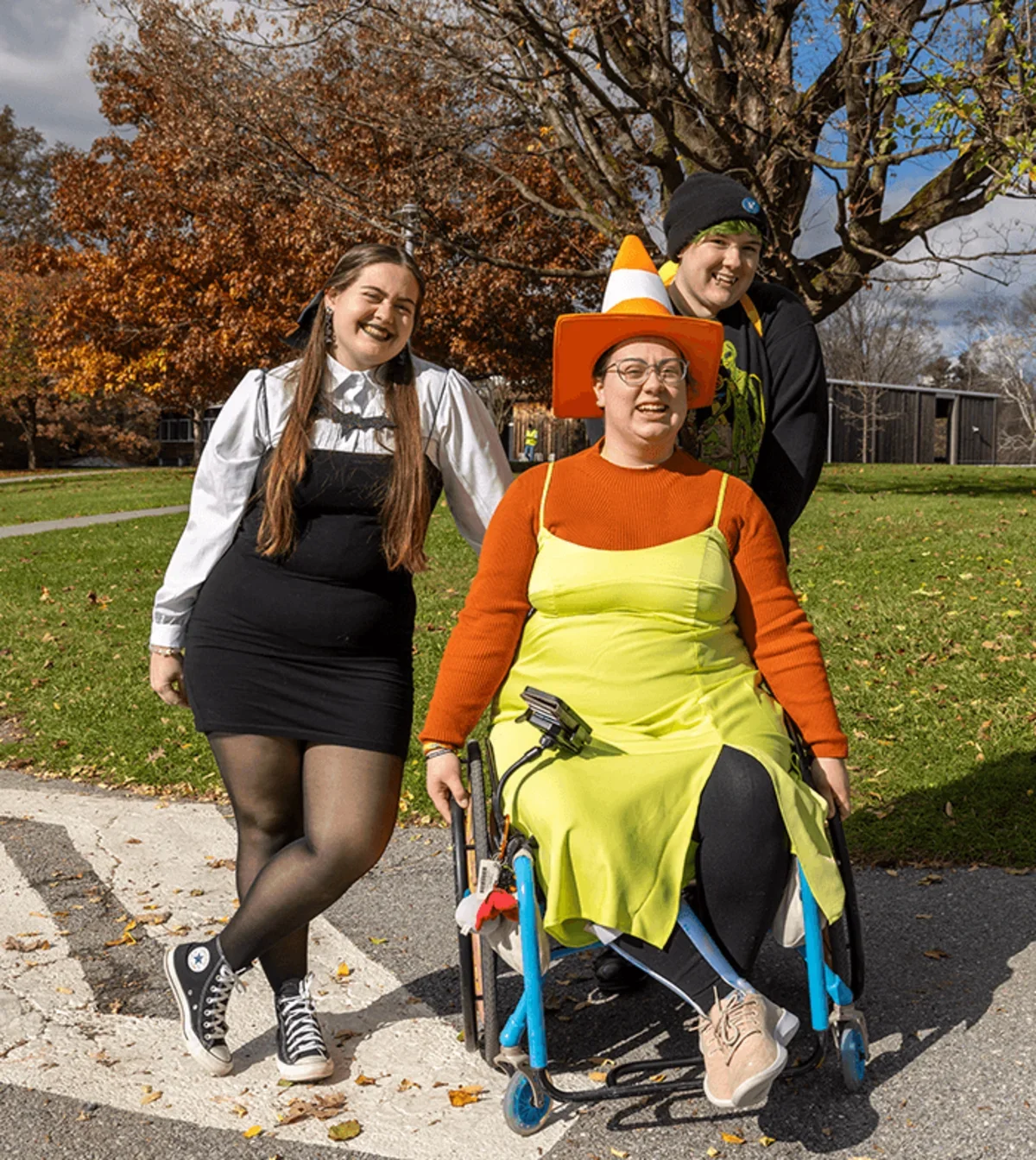 three students pose for the camera wearing their Halloween costumes