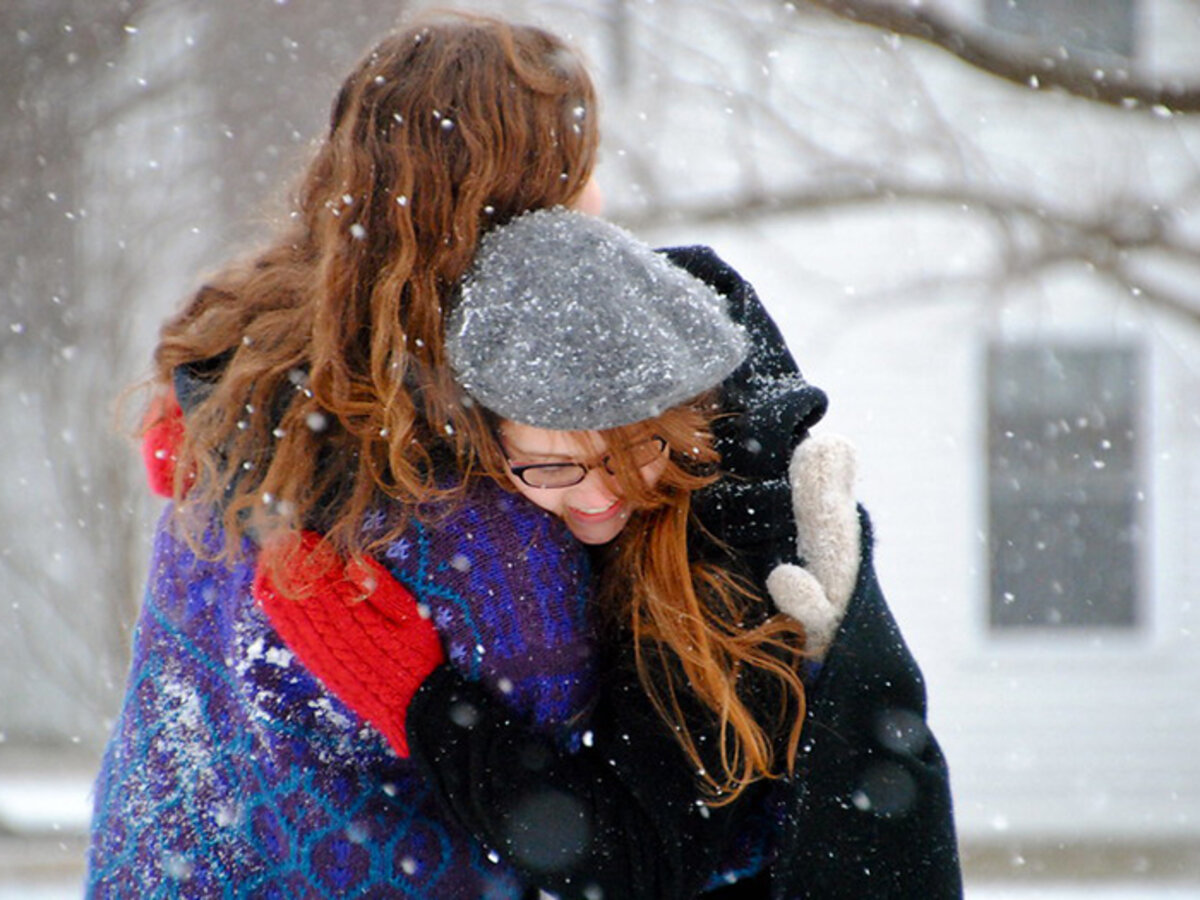 students hugging in the snow