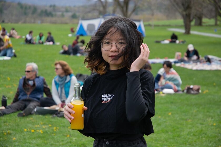 Image of woman standing holding soda