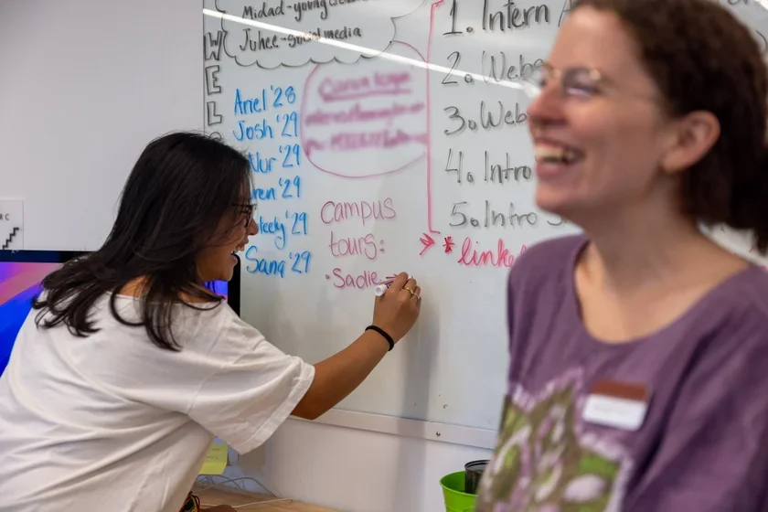 Admissions interns Juhee Kim '29 and Sadie Burch '28 brainstorm ideas on a whiteboard in the Admissions Office. 