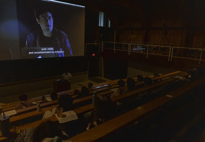 One of the films plays on the screen while the students watch