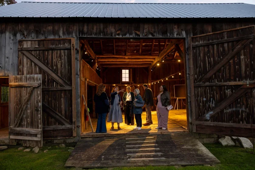 Bennington College Board members tour the newly electrified barn at the Robert Frost Stone House Museum. 