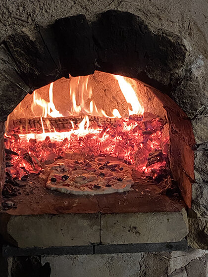 Image of pizza in cobb oven