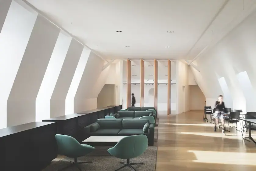student lounge with white walls, long windows and green couches