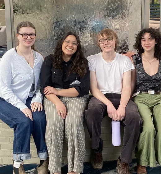 Image of four students smiling in hotel
