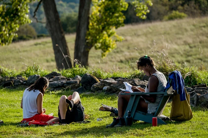 students gather to read and write together outdoors in summer